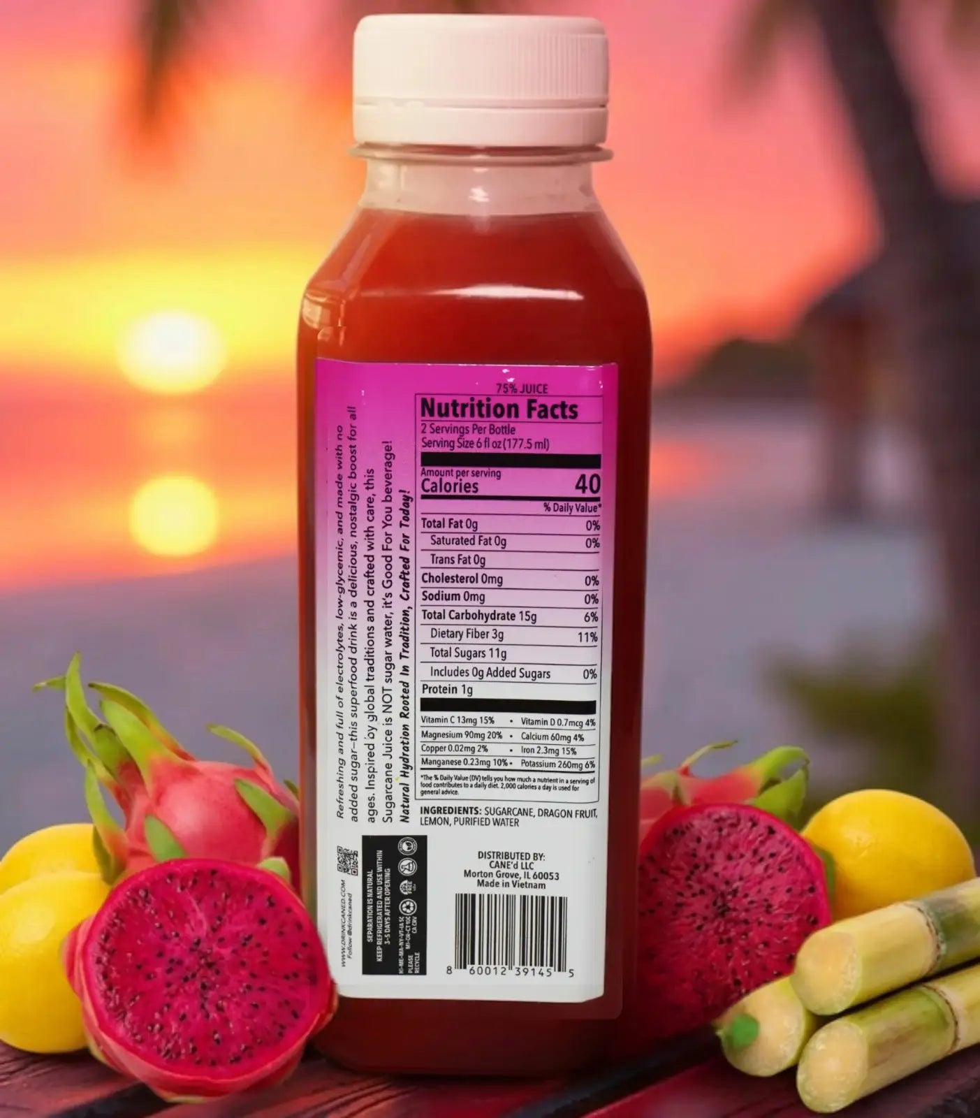 Bottle of juice with nutrition label surrounded by dragon fruit, lemon, and sugar cane against a blurred sunset background