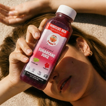 Person holding a bottle of hibiscus red sugarcane juice.